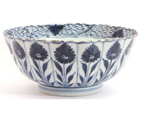 A Chinese  porcelain bowl, Kangxi, the fluted body decorated with alternating flowerheads in Ming style. Kangxi motif to base