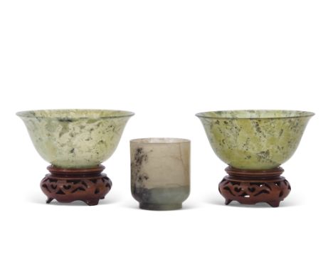 Two spinach green jade small bowls on wooden bases, together with a further small jade cup (3)