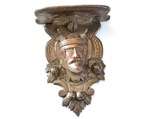 Unusual oak wall bracket, the support carved in the form of a Royal head encrusted with nuts and foliage, 48cm high