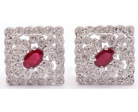 Pair of diamond and ruby cluster earrings, an off-square design centring an oval faceted ruby within a diamond set pierced su