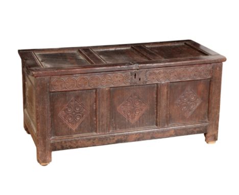 A 17TH CENTURY OAK CONVERTED COFFER of rectangular form, with a carved panel front and a hinged lid containing a lead lined i
