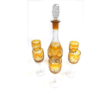 A Bohemian amber flash glass decanter and stopper, floral engraved, together with five stemmed wine glasses. (6) 