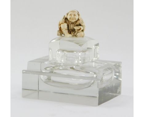 A Victorian cut glass inkwell, of rectangular section, the lid later surmounted with a Japanese netsuke carved as a seated ma