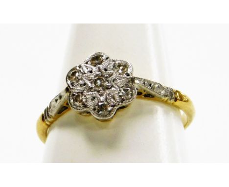 An 18ct gold and diamond seven stone flower head ring, size K, 2.2g. 