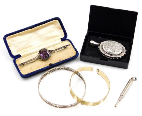 A filigree hinged bangle, white metal unmarked, an amethyst coloured paste stone set bar brooch, with cantilevered scroll sid