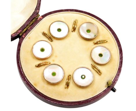 A cased set of rose gold collar studs, each with mother of pearl decoration and central green paste stone, in a yellow metal 