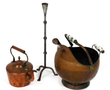 A copper helmet shaped coal scuttle, together with a copper kettle and a wrought iron rush light. 