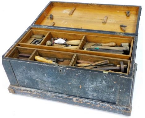 A stained wooden carpenter's tool chest, containing an assortment of tools in a double length tray top, based on castors, 52c