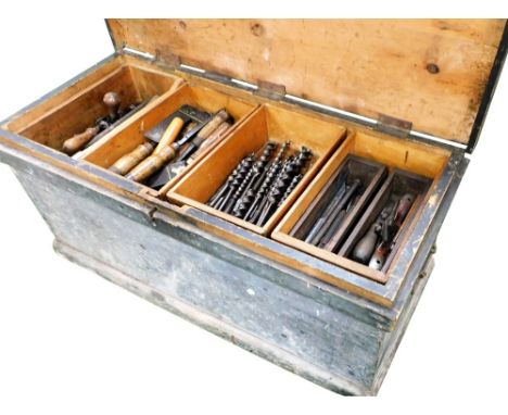 A carpenter's stained pine tool chest, containing moulding planes, saws, chisels, drill bits, set squares, etc., 99cm wide.