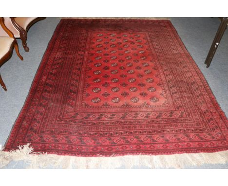 Turkmen carpet, North Afghanistan, the faded crimson field with columns of quartered guls enclosed by multiple borders, 277cm