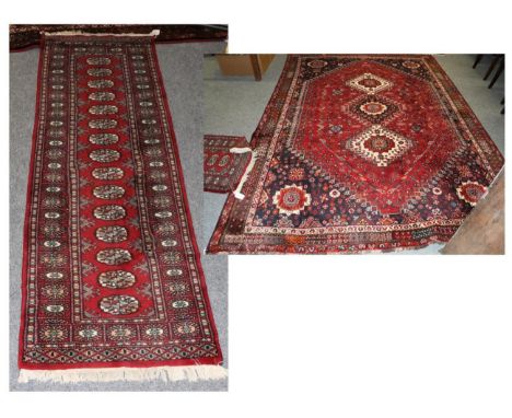 Kashgai carpet, South West Iran, the raspberry field with three ivory medallions framed by spandrels and narrow borders, 300c