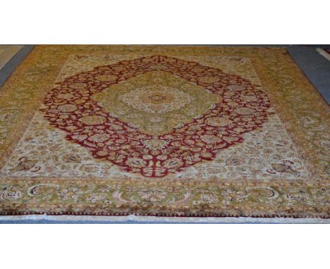 Agra design carpet, Indian, the raspberry field with vines around an olive green medallion framed by spandrels and floral bor