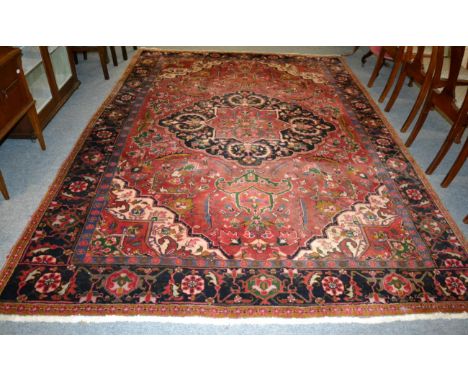 Heriz carpet, Iranian Azerbaijan, the raspberry field with indigo medallion framed by spandrels and samovar motif borders, 32