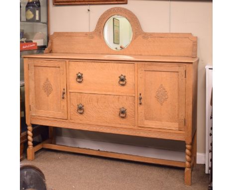 Early 20th Century light oak sideboard having mirror back, fitted two drawers flanked by cupboard doors, raised on barley twi