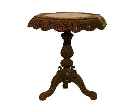 Burmese heavily carved hardwood octagonal top table, the top having a shaped apron, standing on a turned baluster pillar and 