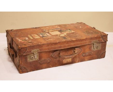 Vintage leather suitcase covered with various destination labels   Condition: 