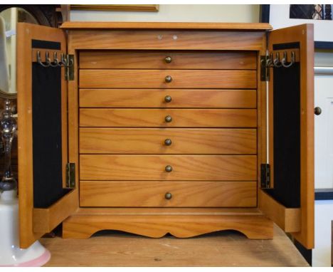 Modern light ash effect jewellery cabinet fitted various drawers enclosed by a pair of blind panel doors   Condition: 