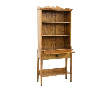 An oak bookcase, by Arthur Simpson of Kendal, with a three-quarter gallery, three shelves over a hinged shelf, an undertier b