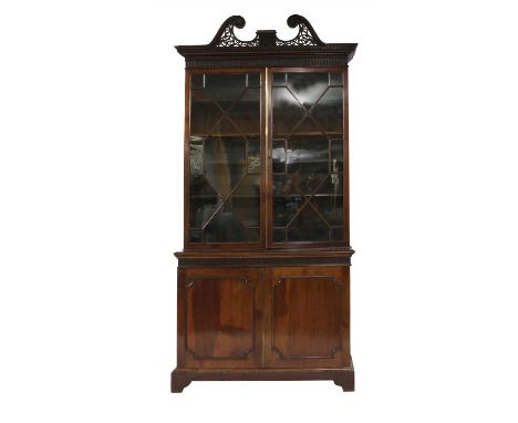 A late 19th century mahogany bookcase , with a fret work broken arch atop a dentil cornice over astragal glazed doors, with c