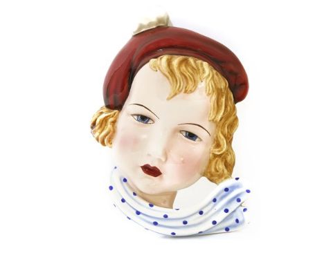 A Goldscheider wall mask, by Stephan Dakon, no. 7412, modelled as a girl wearing a beret and a spotty scarf, stamped and prin