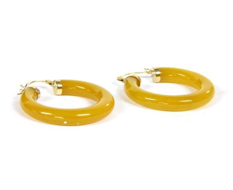 A pair of carved jade hoop earrings, marked 14k