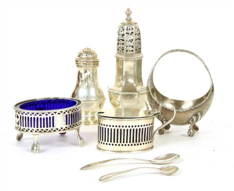 A hallmarked silver castor, with pierced top and turned finial, together with a miniature basket, one other shaker, a salt an