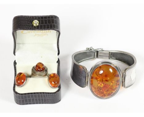 A silver and amber mounted hinged bangle, bearing control marks and a matching silver ring and ear studs, 55gm 