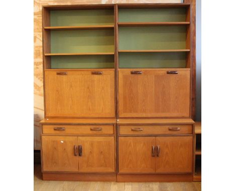 A pair of 1970s G-Plan teak wall units, comprising of two base units with central long drawer over two door cupboards, two se