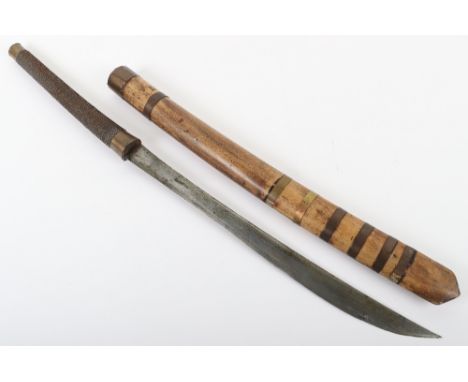 Burmese Sword Dha, housed in wooden scabbard with brass mounts. Grip with wire binding covering and brass pommel. Slightly cu