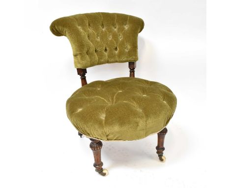 A button press green velour upholstered low side chair, raised on turned supports to castors.