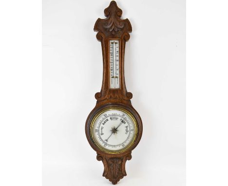 An early 20th century oak cased barometer of banjo form, the white glass face inscribed 'Storm - Rain - Change - Fair - Very 