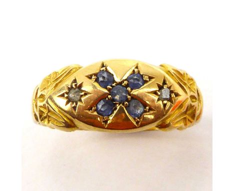 An 18ct gold ring with cross-shaped pattern, incorporating four small blue stones, flanked by two tiny rose cut diamonds, siz