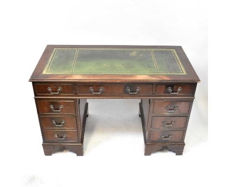 A modern reproduction pedestal desk, the inset green leather top over three small drawers, on two pedestal banks of three dra