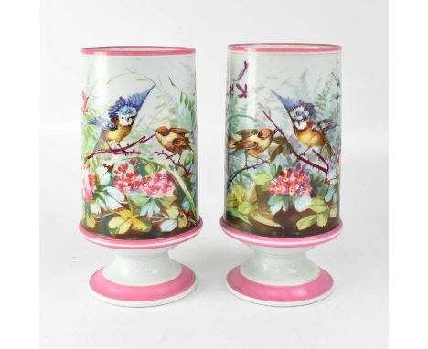 A pair of Victorian painted opaque glass vases decorated with flowers within a pink border, height 34cm (2).Condition Report: