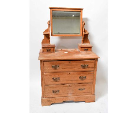 A 20th century pine dressing chest with bevelled mirror plate above two short jewellery drawers and a base of three long draw