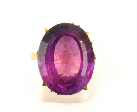 A Continental gold dress ring with an oval cut claw set amethyst stone, size P, approx. 8.5g.Condition Report: - Stamped on t