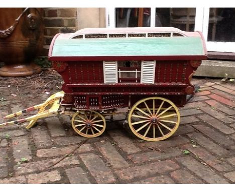 An approximately ? scale Gypsy Caravan, constructed in wood and painted in maroon with yellow shafts and wheels, blue/white r