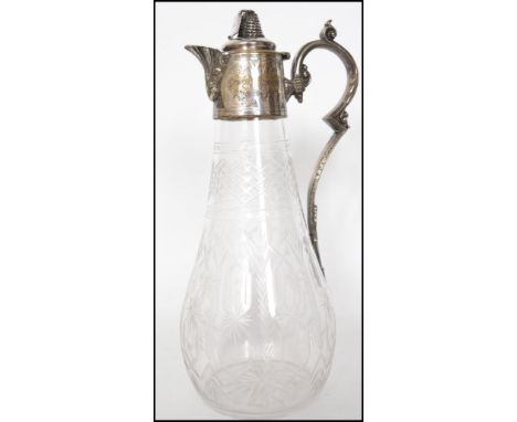 A Georgian cut glass claret jug having a silver plated top and spout with etch work decoration through out the body having a 