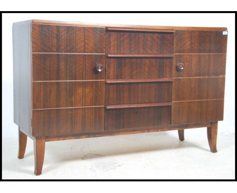 A vintage 20th century teak wood sideboard having a series of beehive drawers and cupboards raised on tapered legs united by 