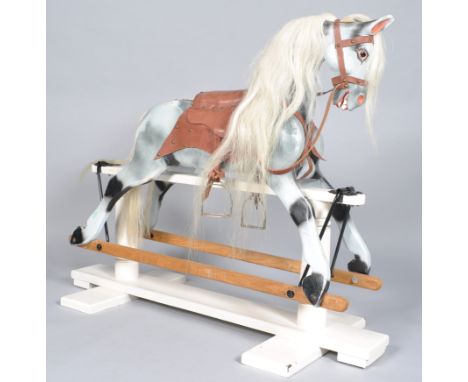 A 20th century carved wood and painted rocking horse with white horse hair mane and tail, leather saddle and bridle, 97cm hig