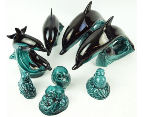 A group of Poole pottery animals, comprising a pair of large leaping dolphins atop waves, 29cm wide; another smaller with sim