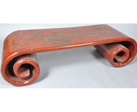 A Chinese style red japanned coffee table, on scroll supports decorated with flowers and butterflies, 42.5cm high x 161cm wid
