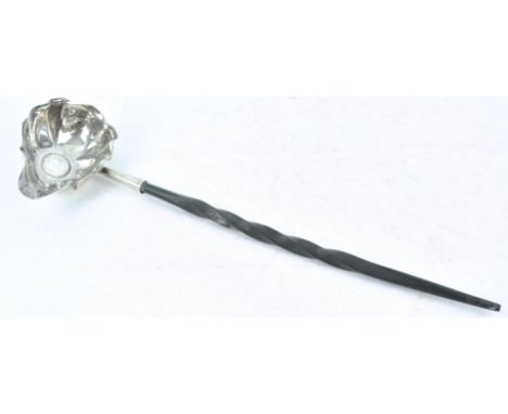 A white metal toddy ladle, with shaped bowl set a 1787 shilling, on a twisted baleen handle, 32cm long
