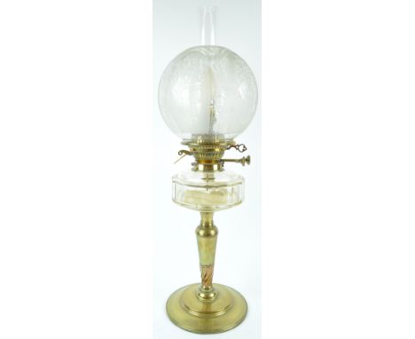 A late 19th century brass oil lamp with cut glass reservoir, chimney and etched globular shade, 62cm high