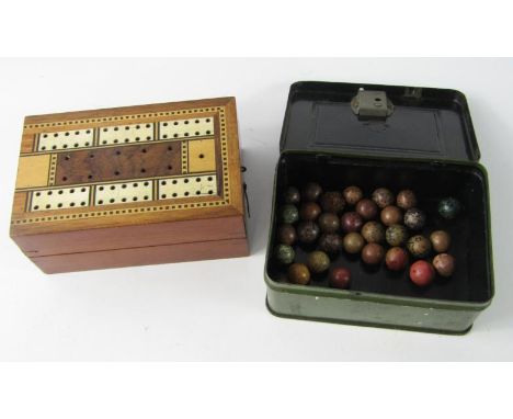 A safe form cash tin containing vintage marbles, together with a box form cribbage board. (2)