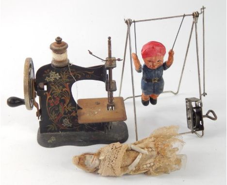 A Victorian child's sewing machine, Victorian bisque doll, 12cm long and a clockwork acrobat. (3, AF)