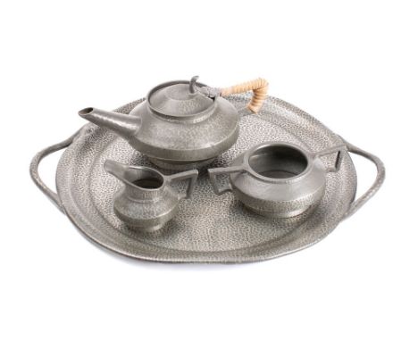 An Arts & Craft influence pewter three-piece tea service: together with circular serving tray with loop handles to the sides,