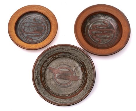 *John Leach [1939-2021] Muchelney Pottery three stoneware dishes: each of circular form and under grey wood ash over tenmoku,