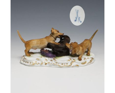 Dackel, mit einem Hut spielend. Meissen. 1901-1923. Modell-Nr. T 20 (neue Form-Nr. 78832).             Breite: 11,5 cm.      