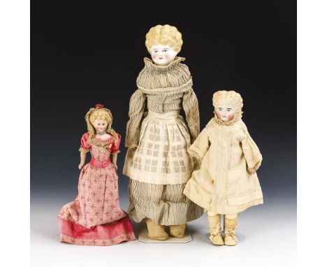 3 blonde Brustkopfpuppen. Ungemarkt. Ende 19. Jh.             Porzellan, Leder, Stoff. L 26-47 cm.             In verschieden